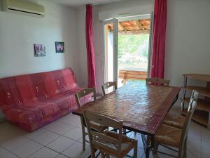 格罗斯皮耶尔雷Domaine des Garrigues的客厅配有桌子和红色沙发