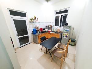 大叻Môn Bạc Home的一间带桌子和冰箱的小厨房