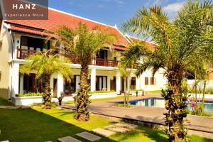 琅勃拉邦Sunrise Hotel Luang Prabang MekongRiver的棕榈树和游泳池度假村