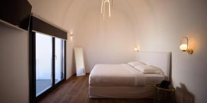 易莫洛林LF Suites & Villas的白色的卧室设有床和大窗户
