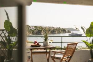 梅加利阿莫斯Nimfi Hotel, Skiathos的阳台配有桌椅,享有水景