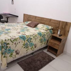 马卡帕Aeroporto House的一间卧室配有一张带木制床头板和一张桌子的床。