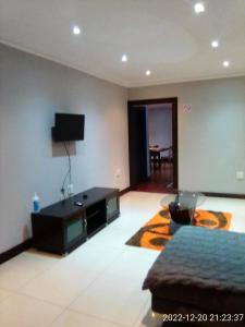 德班Mkhandi Self Catering的客厅配有沙发和墙上的电视