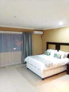 德班Mkhandi Self Catering的一间卧室设有一张大床和一个窗户。