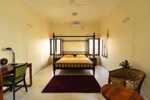 班加罗尔Luho 187的一间卧室配有一张床、一张桌子和一把椅子