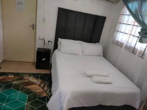 约翰内斯堡Erima Lodge的一间卧室配有一张大床和两条毛巾