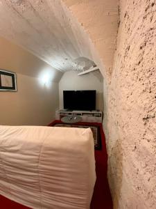 加普Gîtes de Chauvet的卧室配有白色的床和电视
