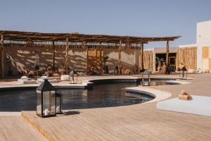 达赫拉Caravan by Habitas Dakhla的一个带游泳池和凉亭的度假村