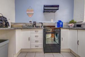 伯诺尼Ovendales Self Catering Cottage的厨房配有白色橱柜和黑烤箱。