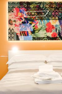 奥斯图尼Ostuni Luxury Room的床上挂着一幅画,上面有白色枕头