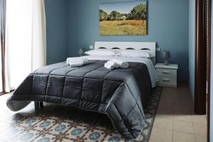 帕拉比塔Agriturismo Paradiso的一间蓝色客房内配有一张大床的卧室