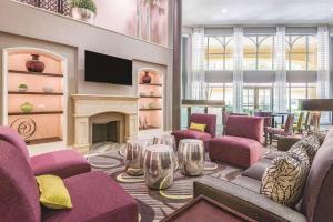 达拉姆La Quinta Inn & Suites by Wyndham University Area Chapel Hill的客厅配有紫色椅子和壁炉