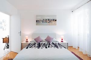 韦利拉特萨卡伦旅馆的白色卧室配有一张带紫色枕头的大床