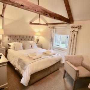 诺里奇Kings Head Bawburgh的一间卧室配有一张大床和一把椅子