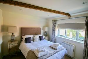 诺里奇Kings Head Bawburgh的一间卧室配有一张带白色床单的床和一扇窗户。