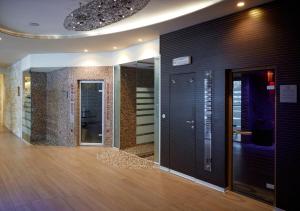 蓬泰迪莱尼奥阿克夸西亚蓝色酒店的一间设有走廊、黑色门和木地板的客房