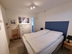 德科赫Zilt Zand的一间卧室配有一张大床和一把椅子