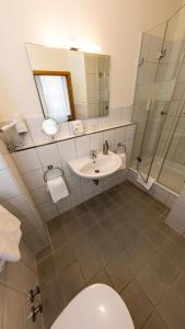 汉堡瓦尔酒店的一间带卫生间、水槽和镜子的浴室