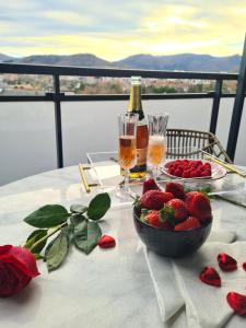 伊伦Apartamento Nicores Bidasoa的一张桌子,上面放着一碗草莓和一瓶香槟