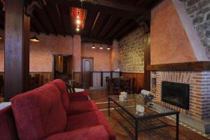 杜鲁埃洛德拉谢拉卡斯特罗维约旅馆的客厅设有红色的沙发和壁炉