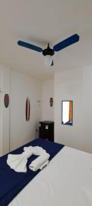 萨夸雷马POUSADA ARKAN BEACH的一间卧室配有一张带白色床单的床和吊扇。