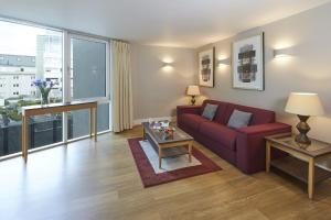 伦敦Marlin Apartments London Bridge - Empire Square的客厅配有红色的沙发和桌子