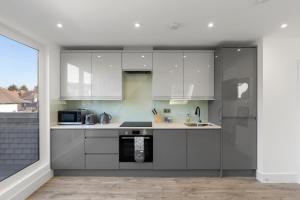 The HydeFlat 5 - Star London Vivian Lane 2-Bed Residence的厨房配有白色橱柜和炉灶。