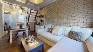 斯特拉斯堡LE NID DE L'ILL, Magnifique Duplex Cosy Petite France的客厅配有白色沙发和砖墙