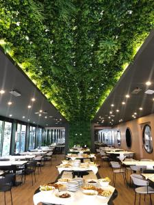 博洛尼亚JR Hotels Bologna Amadeus的一间带桌椅和绿色天花板的餐厅