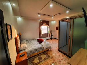 达赫拉DARKOM的一间卧室设有一张床和一个玻璃淋浴间