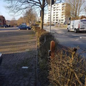 弗伦斯堡Stadtnah an der Förde 104的街道旁的围栏,街上有汽车停放