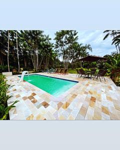 帕拉蒂Vila Noah Pousada的庭院内带桌椅的游泳池