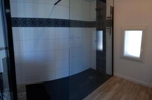 MonbahusL'atelier d'André的浴室里设有玻璃门淋浴
