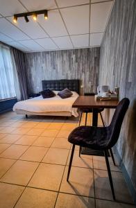 亨克德沙赫特酒店的一间卧室配有一张床、一张桌子和一张桌子