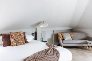 斯希丹Havendijk Hotel的卧室配有白色的床和沙发