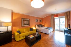 坎诺比奥Aquazzurra Resort & Aparthotel的酒店客房设有床和黄色沙发