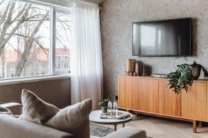 斯希丹Havendijk Hotel的客厅的墙上配有电视