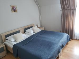 Melturi麦尔图瑞酒店的一间卧室配有蓝色的床和白色枕头