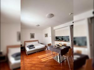坎诺比奥Aquazzurra Resort & Aparthotel的客厅两张照片,配有一张床和一张桌子