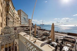 那不勒斯帕特诺普勒莱斯酒店的阳台享有街道和大海的景致。