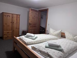 奥伊宾海恩金福斯旅馆及餐厅的一间卧室设有两张单人床和木制橱柜。
