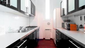 塞格拉泰Italianway - Nona Strada 7的白色的厨房设有水槽和炉灶。