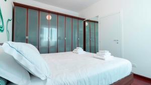 塞格拉泰Italianway - Nona Strada 7的卧室配有一张白色大床和玻璃墙