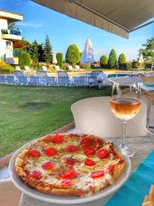 圣弗拉斯Riviera Complex 6的一张桌子上的比萨饼,旁边是一杯葡萄酒