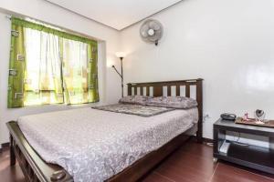 MarilaoBUDER TownHouse Lias Marilao Bulacan Philippines的卧室配有一张床,墙上挂着一个钟