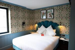 都柏林都柏林迪恩酒店的一间卧室配有一张带花卉壁纸的大床
