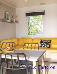 勒克罗图瓦Camping Le Tarteron的客厅配有桌子和黄色沙发