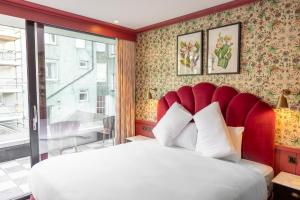都柏林都柏林迪恩酒店的一间卧室配有一张大床和红色床头板