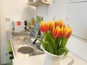 格赖夫斯瓦尔德Ferienzimmer Adalonia的厨房柜台上装满橙色和黄色郁金香的花瓶