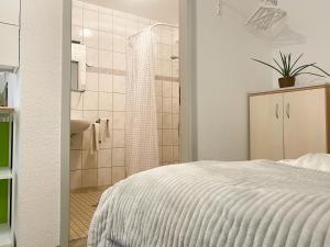 格赖夫斯瓦尔德Ferienzimmer Adalonia的卧室配有白色的床和淋浴